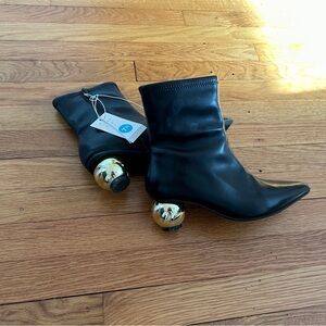Black boots with a gold ball heel